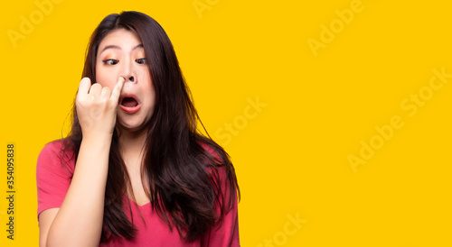 Girl stuffed nose and pick nose by using finger because she can not breath. She get flu and cold. Asian woman running nose and she try to stopping snot running out from her nose. It look disgusting