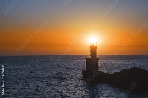lighthouse and sun at sunset at the exit of the port of Pasaia, Euskadi