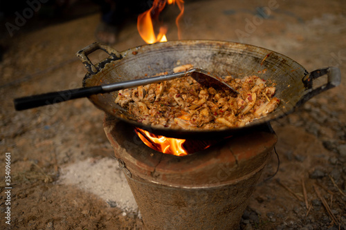To make a fire-laden by using wood as fuel for traditional cooking
