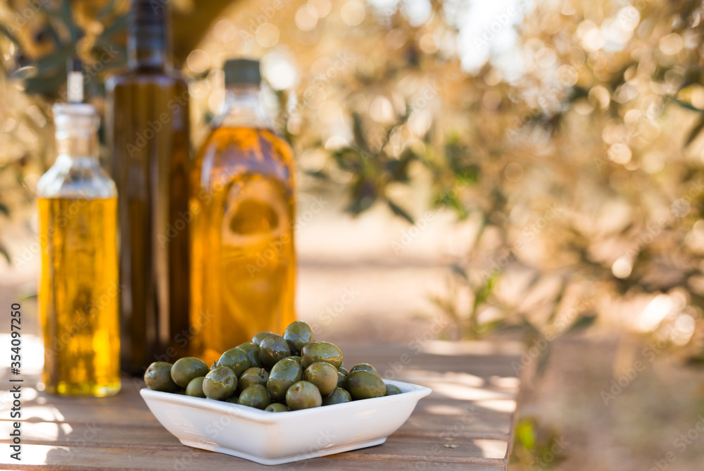 green olives and oil on table in olive grove green olives and oil on table in olive grove