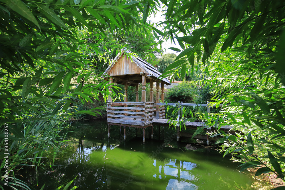 Old wooden arbor on the pond