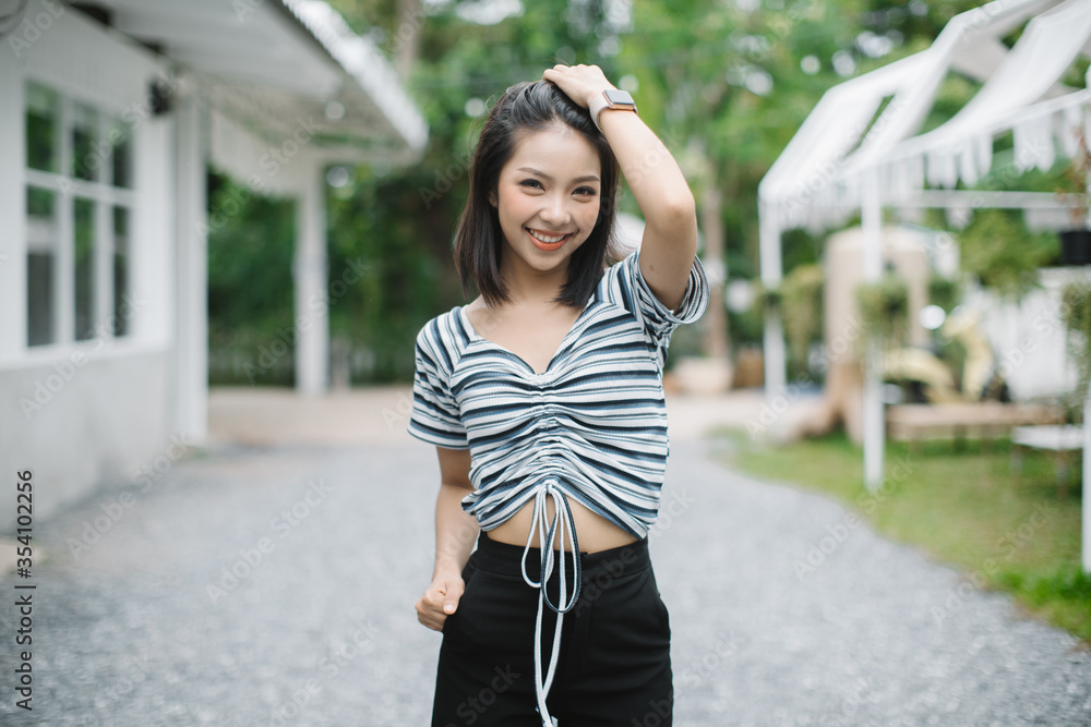 Summer sunny lifestyle fashion portrait of young stylish hipster Asia woman walking on the street, wearing cute trendy outfit Summer sunny lifestyle fashion portrait of young stylish hipster Asia woman walking on the street, wearing cute trendy outfit