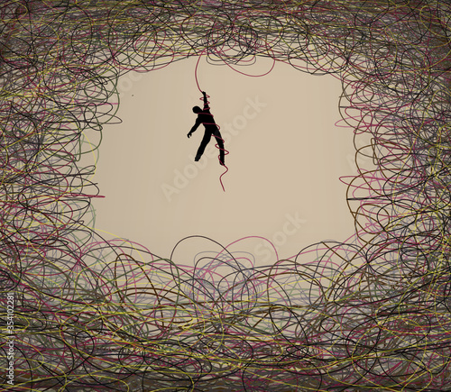 A man hangs on as he is tangled in a chaos of curling tangled colored lines in this illustration. photo