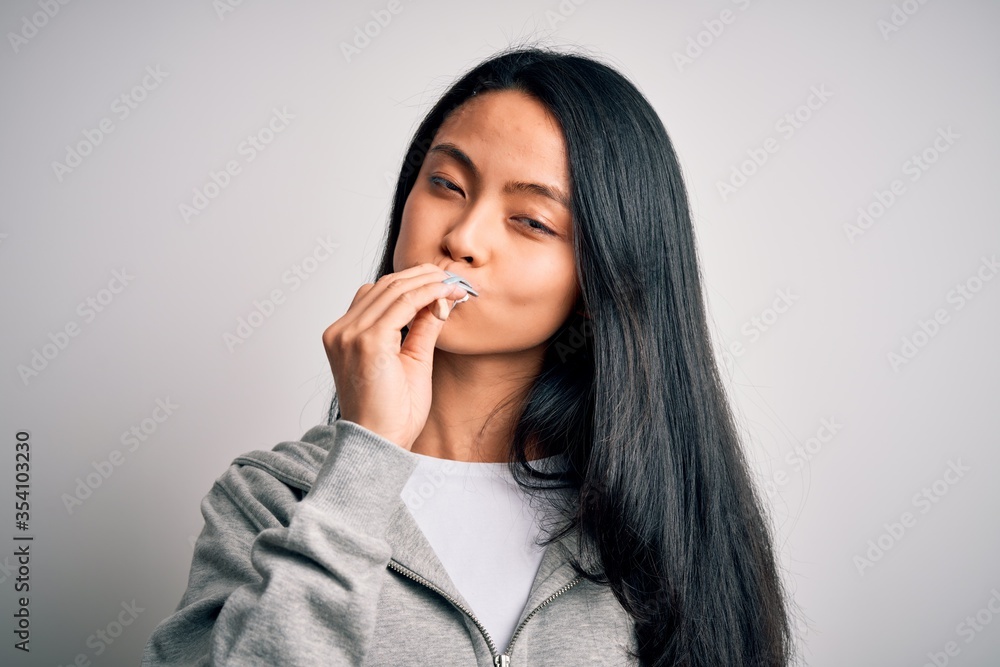 Young beautiful woman standing whasing tooth using toothbrush over isolated white background Young beautiful woman standing whasing tooth using toothbrush over isolated white background