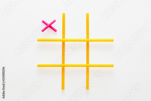 Tic tac toe game made of colorful straws on white background