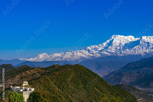 Beautiful sunrise view of mountain range with snowy peaks. Annapurna range in Himalayas. Machchapuchchre/ Fishtail, Annapurna and Himchuli Peaks, view from Sarangkot, Pokhara, Nepal.