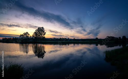 dawn on the Ural lake with trees on the shore in June, Russia, Ural