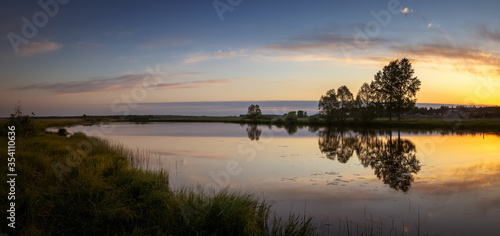 dawn on the Ural lake with trees on the shore in June  Russia  Ural