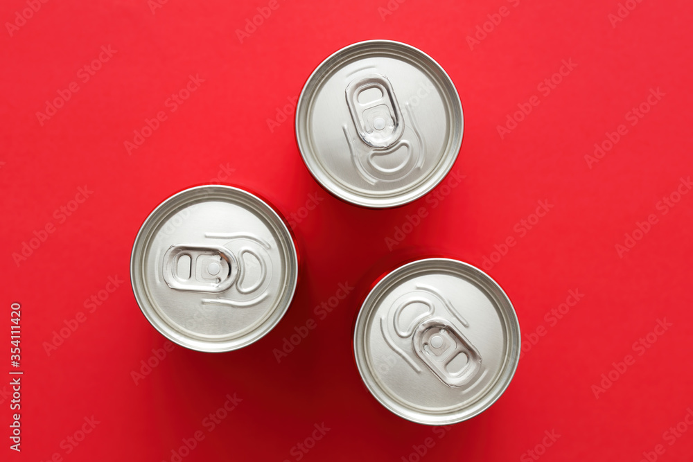 Aluminum drink or beverage cans with pull ring on red background Aluminum drink or beverage cans with pull ring on red background