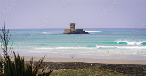 Calm  blue seas and view of La Rocco Tower  St Ouen s Beach  Jersey Channel Islands  UK