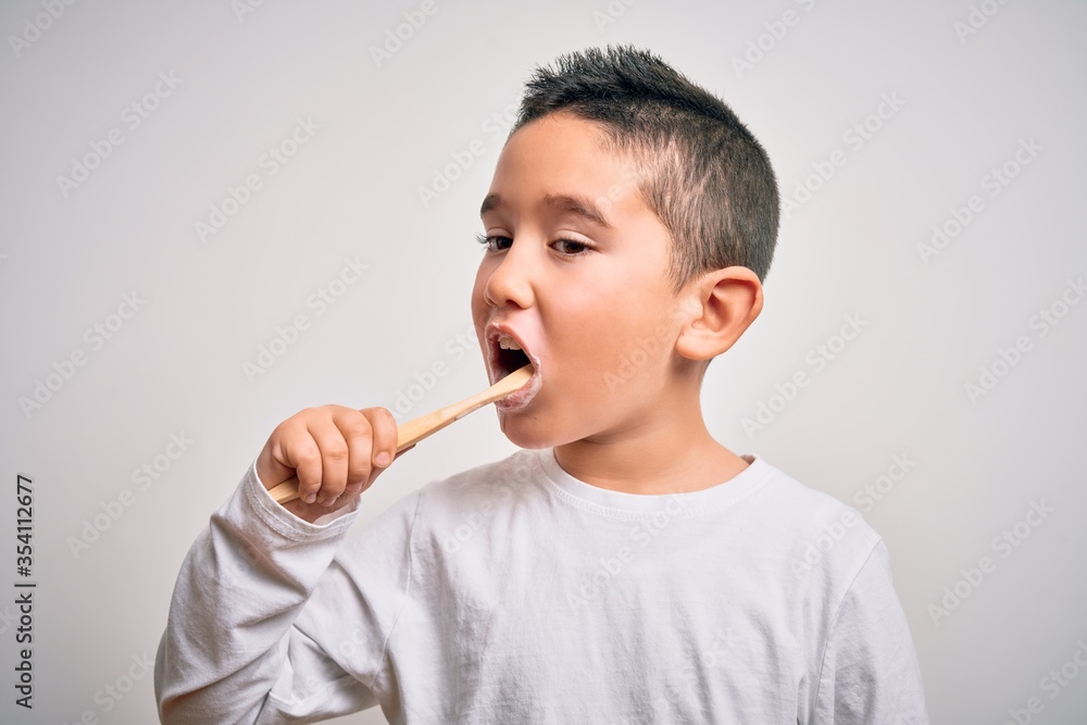 Young little kid boy brushing her teeth using tooth brush and oral paste, cleaning teeth and tongue as healthy health care morning routine. Learning dental education Young little kid boy brushing her teeth using tooth brush and oral paste, cleaning teeth and tongue as healthy health care morning routine. Learning dental education