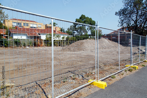 A new housing development under construction. A safety fence restricts access to the construction zone. 