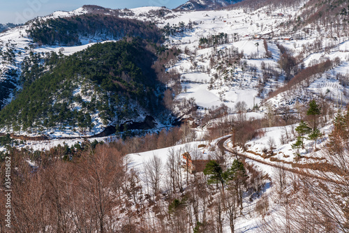 Snowy mountain ridge, chalet, mountain road