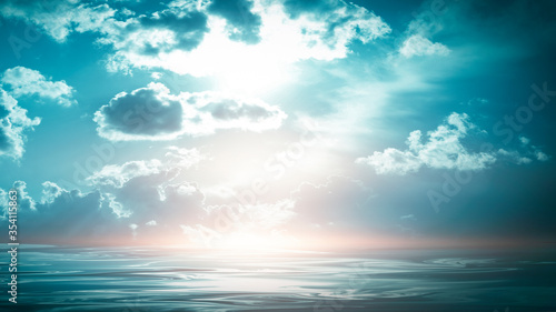 Sea landscape, sea surface. Blue sky, clouds, sunlight, rays. Empty natural scene in the open air. Blurred abstract background. Background of a sea landscape. Blue sky with clouds over the sea.  © MiaStendal