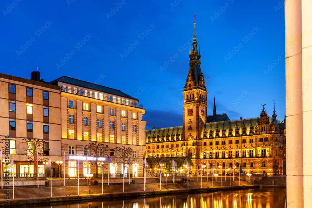 View of Hamburg townhall Rathaus and small Alster lake during twilight sunset.