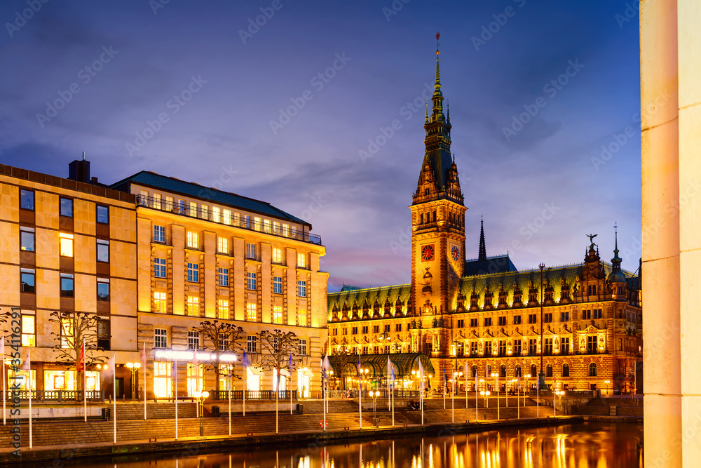 View of Hamburg townhall Rathaus and small Alster lake during twilight sunset.