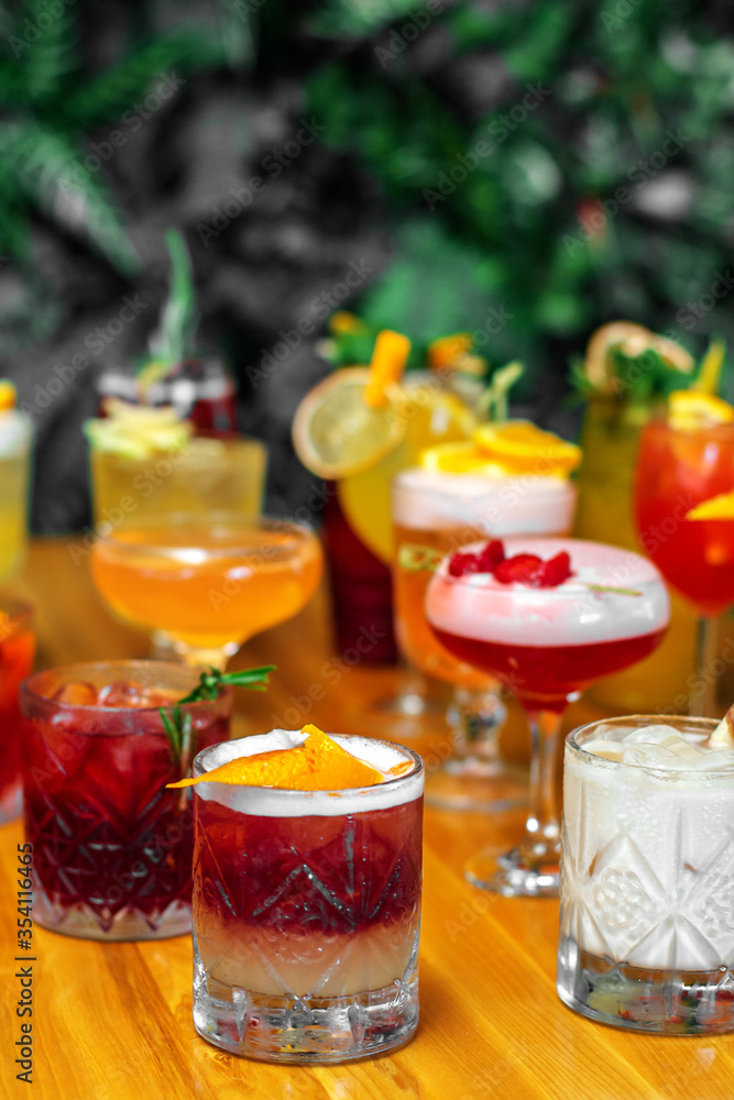 Set of alcoholic multicolor cocktails with fruits on the wooden table. Set of alcoholic multicolor cocktails with fruits on the wooden table.