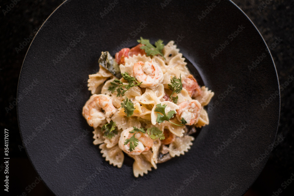 farfalle with shrimp in black plate