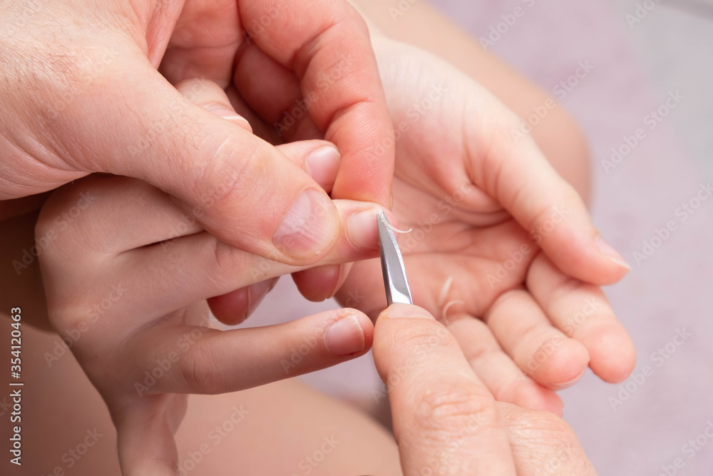 dad cuts his little daughter nails on her hands with scissors dad cuts his little daughter nails on her hands with scissors