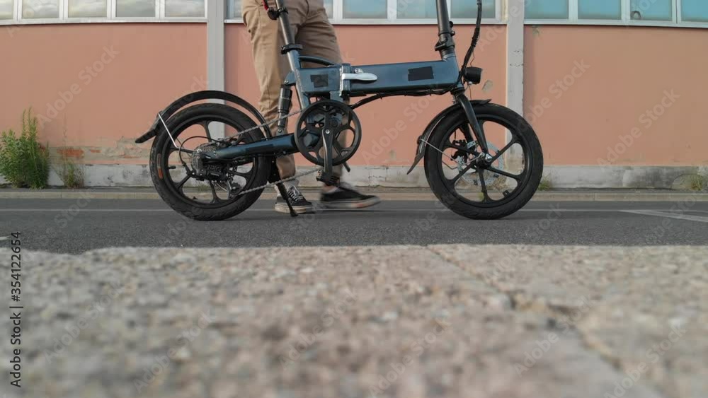 Man takes his foldable bike and departs Man takes his foldable bike and departs