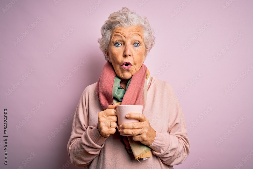 Senior beautiful grey-haired woman drinking mug of coffee over isolated pink background scared in shock with a surprise face, afraid and excited with fear expression Senior beautiful grey-haired woman drinking mug of coffee over isolated pink background scared in shock with a surprise face, afraid and excited with fear expression