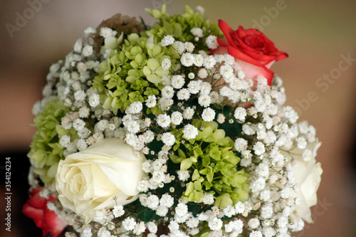 closeup to beautiful bouquet of white and red wedding roses 