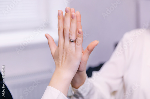 Two young businesswomen giving high five at the office. positive © Ivan