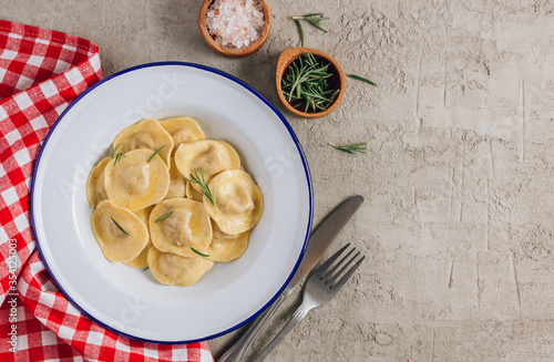 Traditional italian ravioli with rosemary and parmesan served onon an enamel plates. Italian pasta. photo