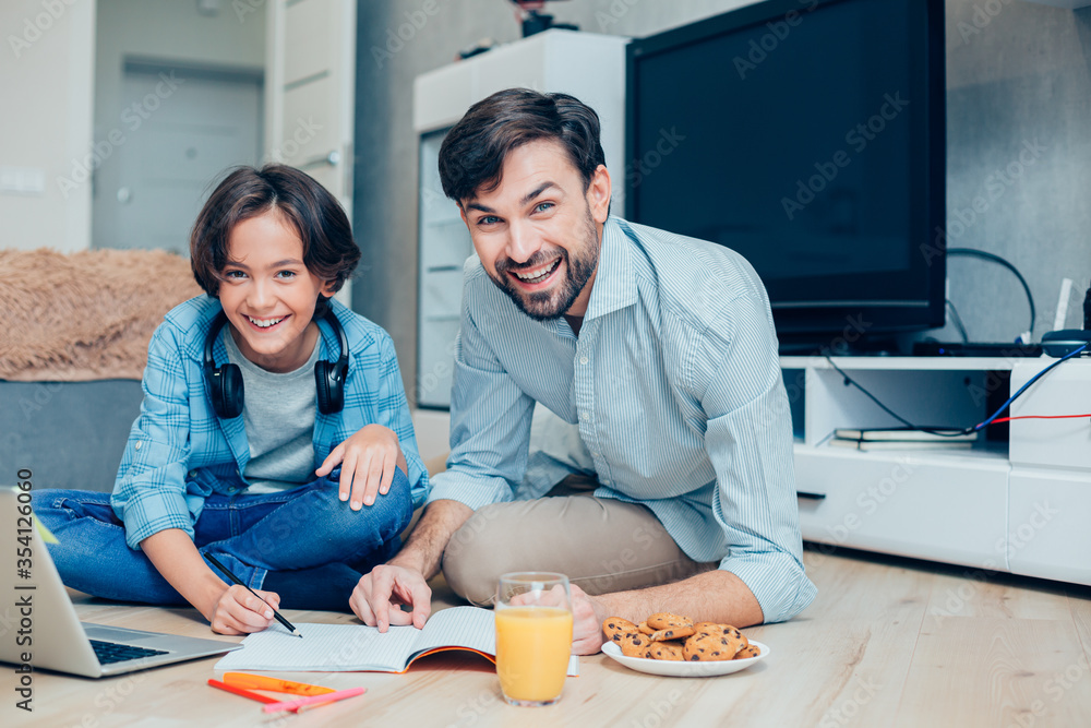 Happy family combining lunch and exciting homework Happy family combining lunch and exciting homework