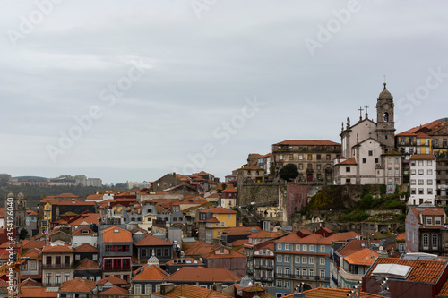 View to Porto's downtown (Portugal) from the cathedral view point. Church on the top of the hill. Portuguese traditional houses with orange roofs.