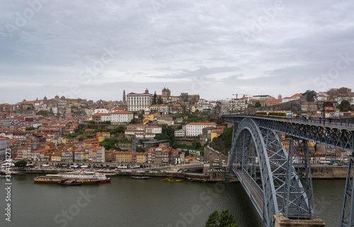 Porto (Portugal) view, with Dom Luís Bridge and metro. Sunset, cloudy sky. Boats on the river. © Daniel Santos