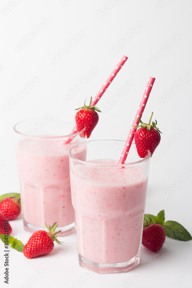 A glass of fresh strawberry smoothie on a white background. Summer drink shake, milkshake and refreshment organic concept. A glass of fresh strawberry smoothie on a white background. Summer drink shake, milkshake and refreshment organic concept.