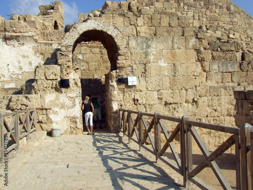 A tourist stands at the entrance to an ancient fortress