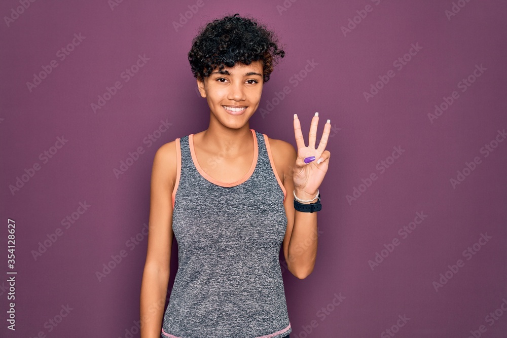 Young beautiful african american afro sportswoman doing exercise wearing sportswear showing and pointing up with fingers number three while smiling confident and happy. Young beautiful african american afro sportswoman doing exercise wearing sportswear showing and pointing up with fingers number three while smiling confident and happy.