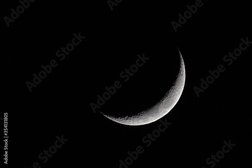 Waxing crescent moon against a black night sky viewed in the northern hemisphere