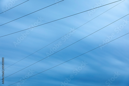 Stromleitungen vor blauem Himmel, Langzeitbelichtung