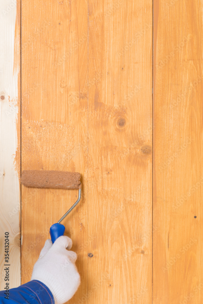 close-up, impregnation of a wooden floor with a dark varnish roller, manually close-up, impregnation of a wooden floor with a dark varnish roller, manually