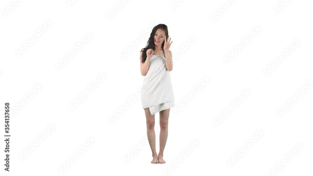 Beautiful young woman wet in towel after shower counting with finger to number 10 using both hands isolated on solid white background. Beautiful young woman wet in towel after shower counting with finger to number 10 using both hands isolated on solid white background.