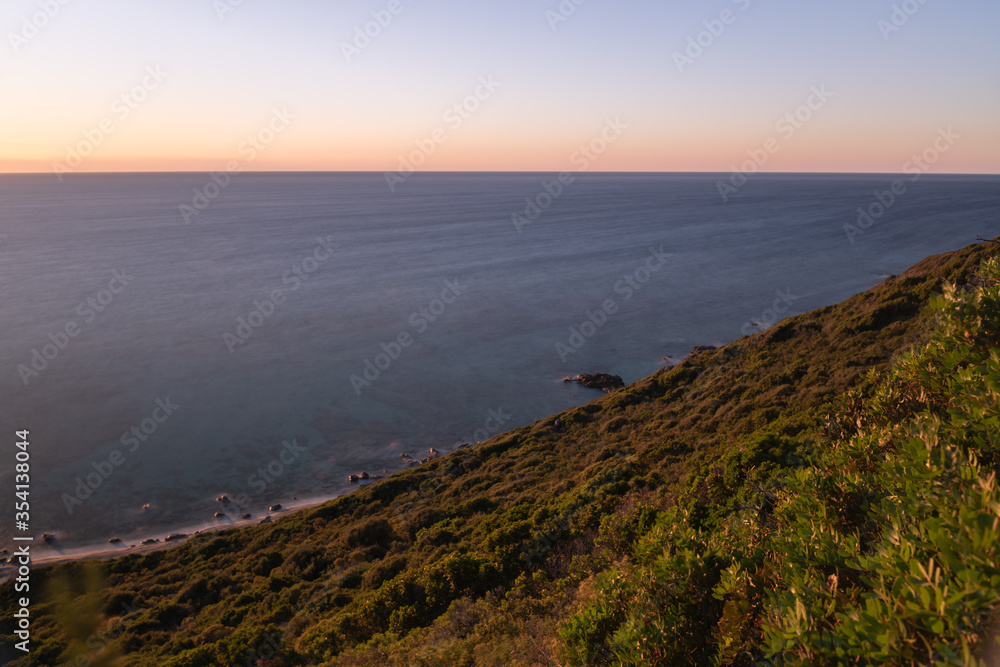 Sunset over the sea and the coastline of the Mediterranean island of Corsica Sunset over the sea and the coastline of the Mediterranean island of Corsica