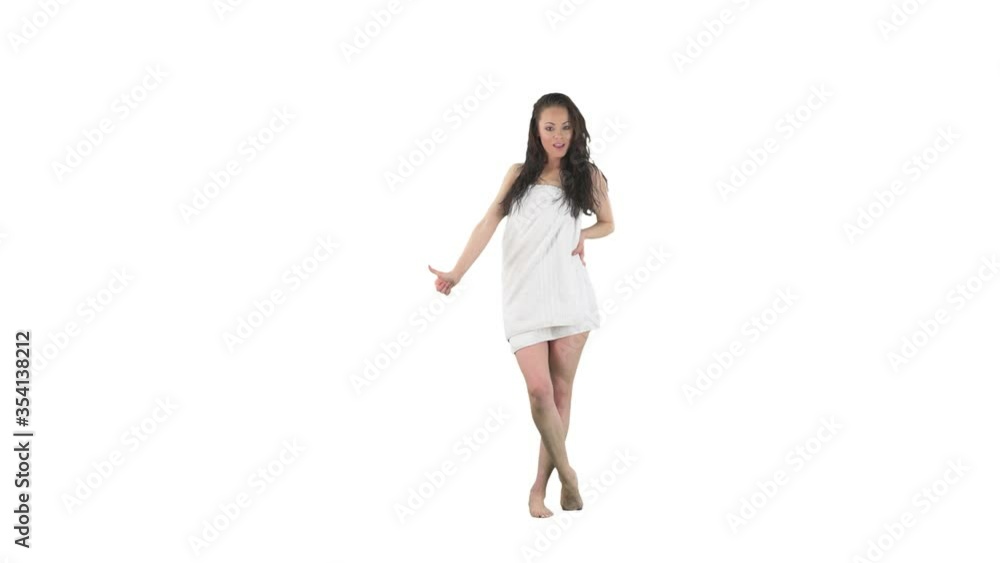 Urgent travel concept. Unprepared young woman with wet hair wearing towel hitchhiking for unexpected journey isolated on solid white background. Urgent travel concept. Unprepared young woman with wet hair wearing towel hitchhiking for unexpected journey isolated on solid white background.