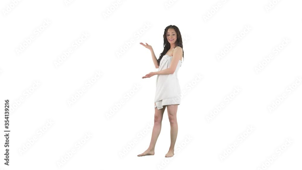 Smiling young pretty woman wrapped in towel with wet hair announcing and presenting empty space isolated on solid white background. Smiling young pretty woman wrapped in towel with wet hair announcing and presenting empty space isolated on solid white background.