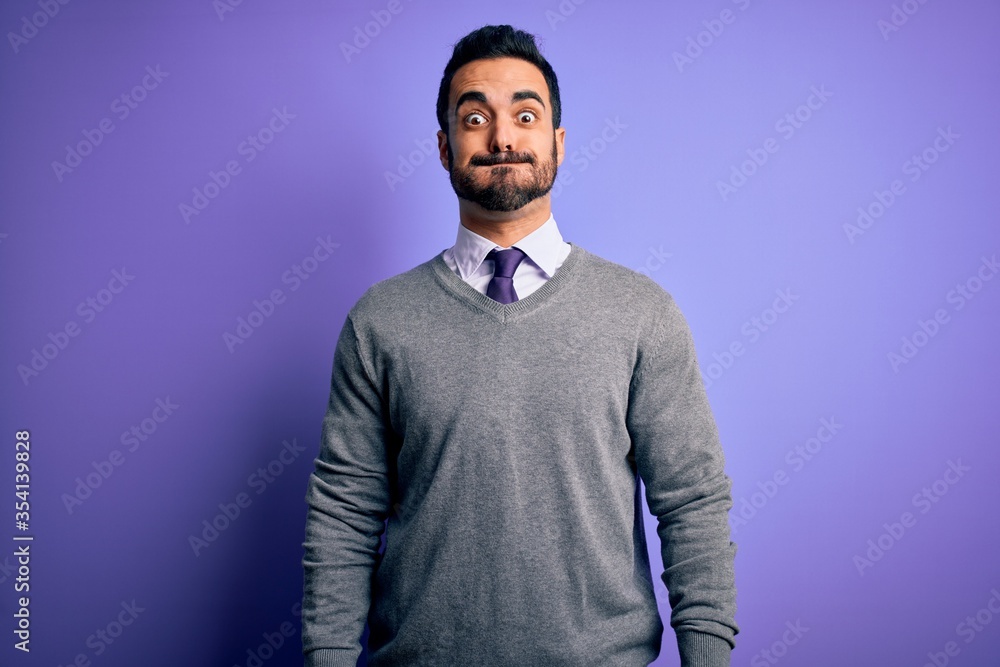 Handsome businessman with beard wearing casual tie standing over purple background puffing cheeks with funny face. Mouth inflated with air, crazy expression. Handsome businessman with beard wearing casual tie standing over purple background puffing cheeks with funny face. Mouth inflated with air, crazy expression.