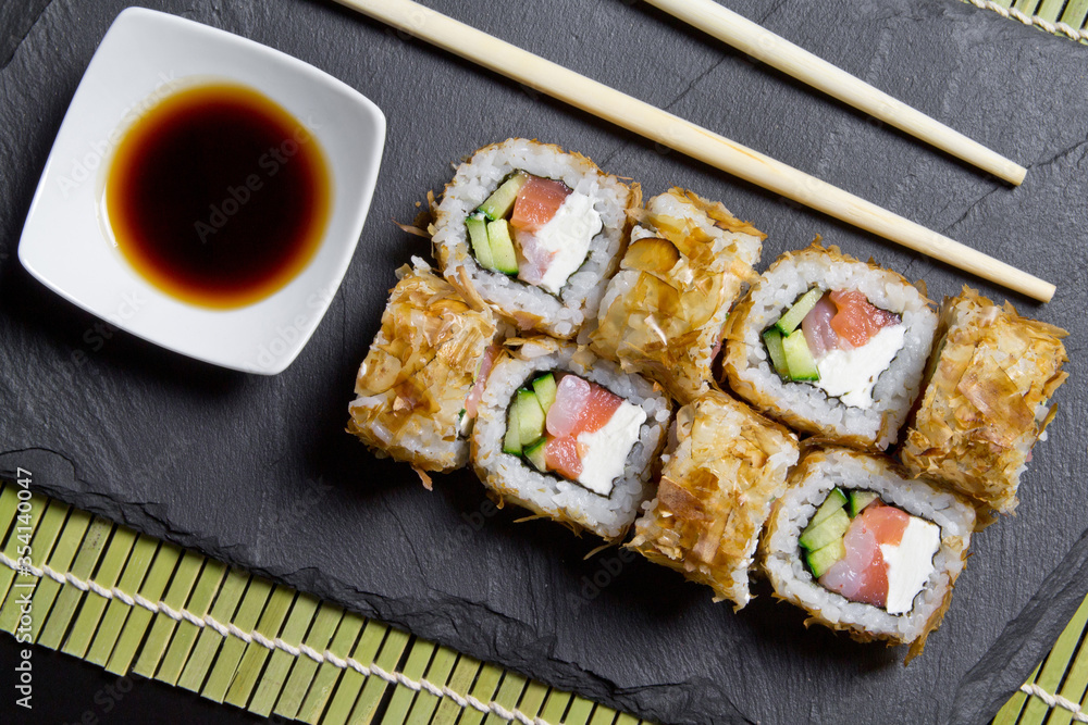 Sushi bonito roll on a dark background. Top view of sushi . Sushi food photo for menu. Sushi bonito roll on a dark background. Top view of sushi . Sushi food photo for menu.