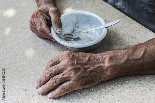 Hungry. Poor old man's hands an empty bowl. Selective focus. Poverty in retirement. Alms photo