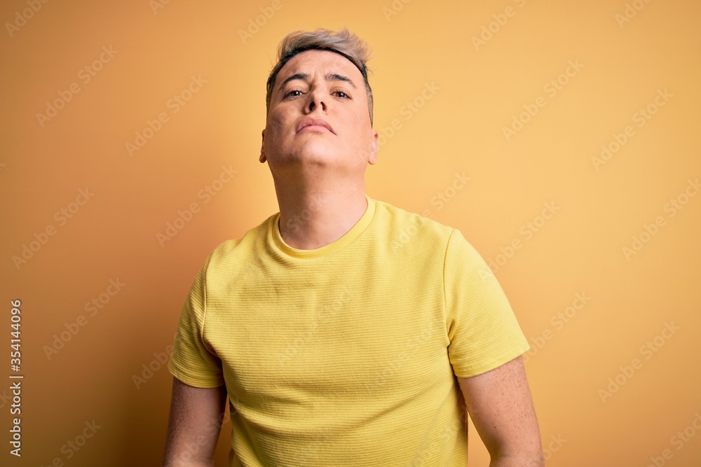 Young handsome modern man wearing yellow shirt over yellow isolated background depressed and worry for distress, crying angry and afraid. Sad expression. Young handsome modern man wearing yellow shirt over yellow isolated background depressed and worry for distress, crying angry and afraid. Sad expression.