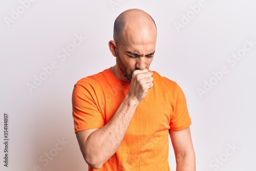 Young handsome bald man wearing casual t shirt feeling unwell and coughing as symptom for cold or bronchitis. health care concept.