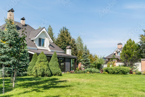 private house with its beautiful garden in a rural area under blue sky photo