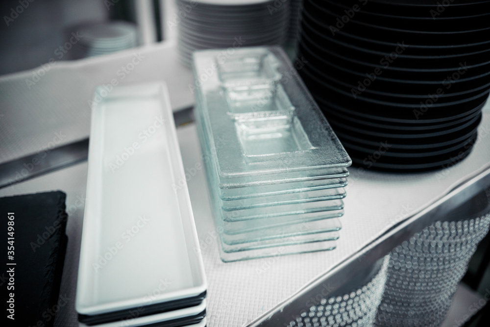 Glass and ceramic dishes are on the shelves. White color plates, close-up Glass and ceramic dishes are on the shelves. White color plates, close-up