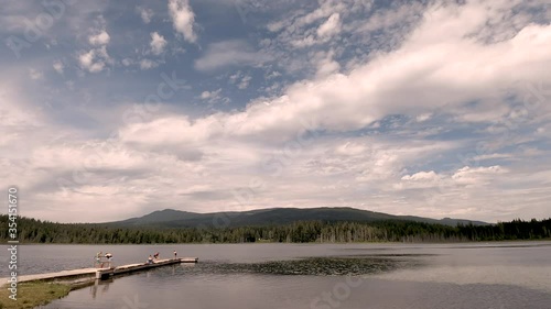 People jumping from the wood dock and swimming at Whonnock Lake in the summertime with cloudy sky. Forest and mountains on the background.
It is a small, man-made lake and rural-residential neighbour photo