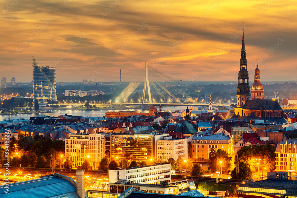Obraz premium Beautiful aerial panorama of Riga center and Vansu bridge over Daugava river during amazing sunset. View of illuminated Riga city, capital of Latvia.